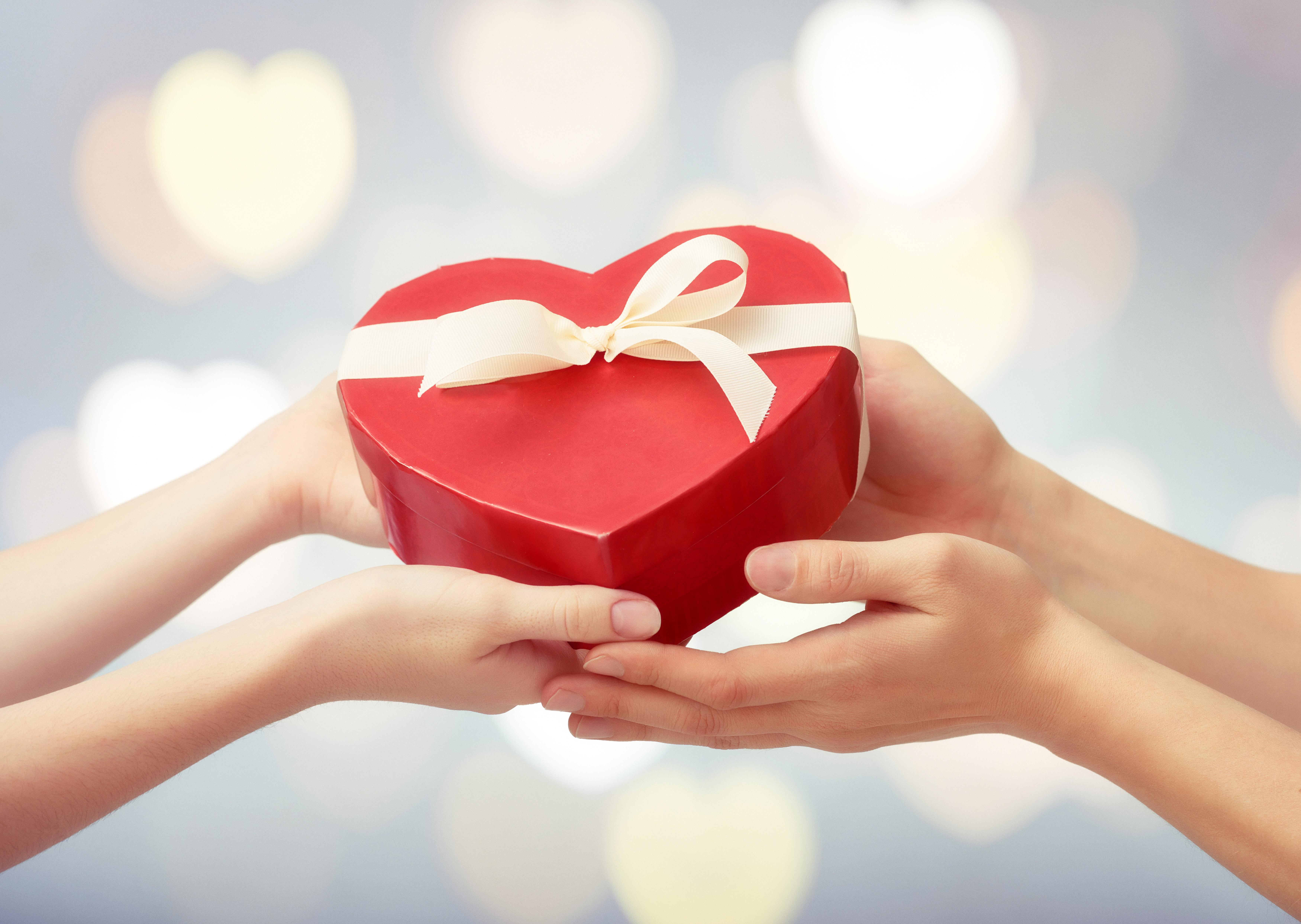 Преподносит приятные сюрпризы. Сердце подарок. Красивые подарки. Подарок в руках.