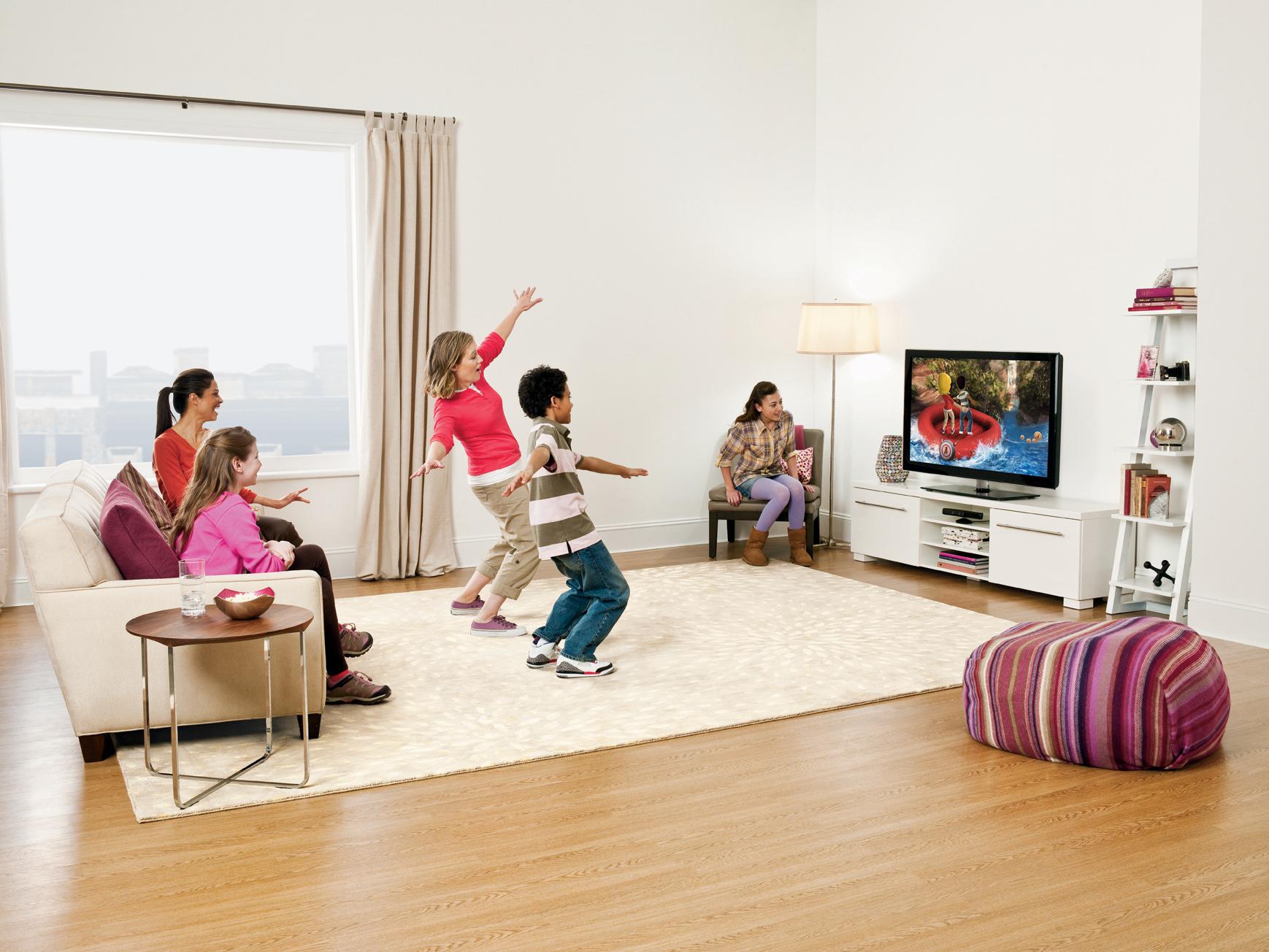 Поиграем в игру на телевизоре. Дети играют в гостиной. Играющие дети в квартире. Дети играют в комнате. Танцы перед телевизором.